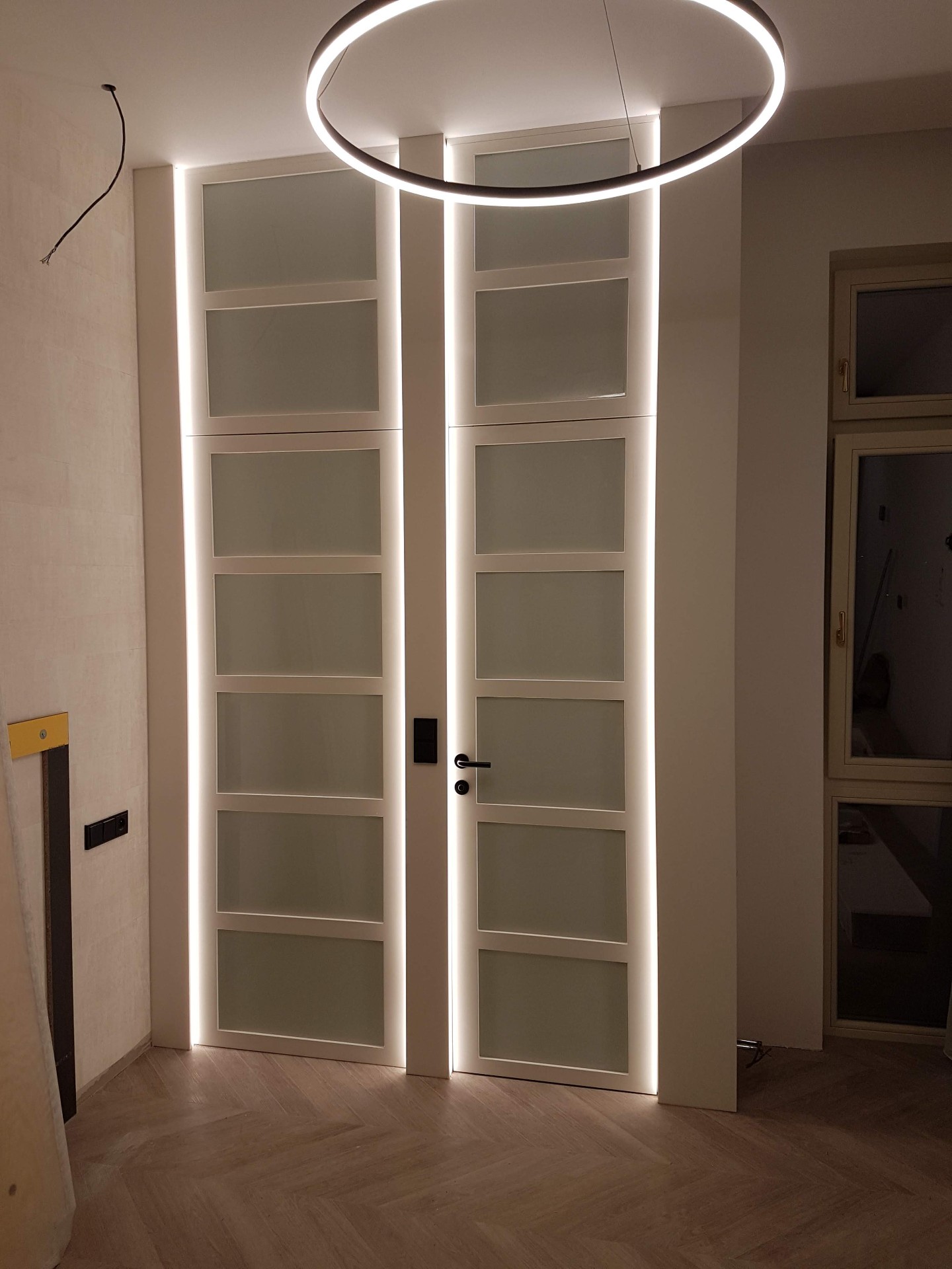 Vysoké bílé dveře s matným sklem a LED rámem